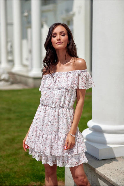 Robe bohème fleurie blanche courte avec épaules dénudées et silhouette trapèze, idéale pour plage ou sortie estivale.