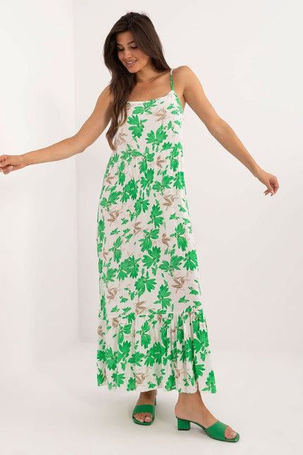 Robe d'été longue blanche à motif floral vert, style bohème chic avec bretelles fines.