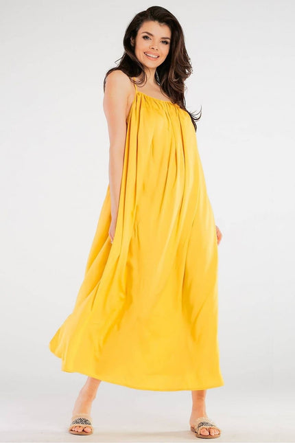 Robe jaune fluide midi pour soirée estivale ou cocktail, sans manches avec une silhouette trapèze, idéale pour un look décontracté chic.