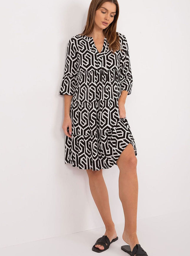 Robe mi-longue trapèze noire et blanche à motif géométrique, manches trois-quarts, idéale pour look casual ou bureau.