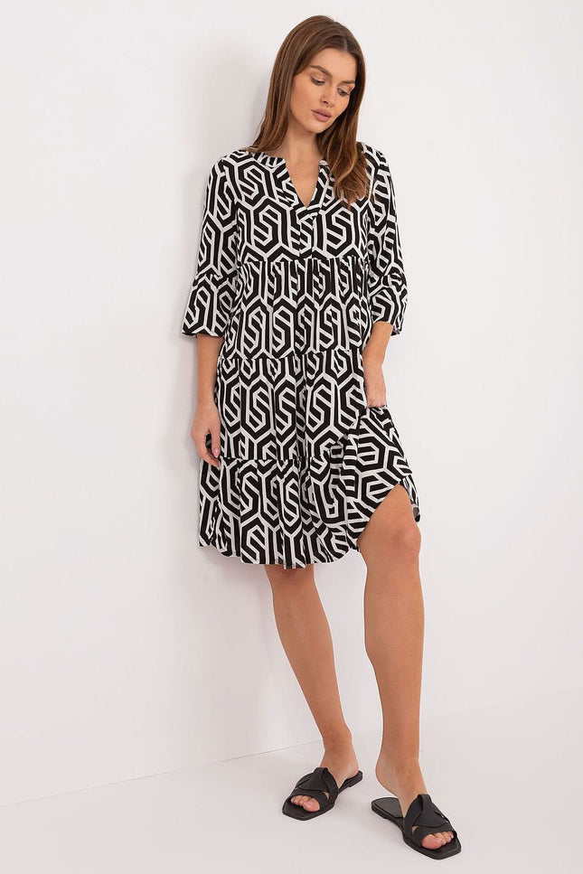 Robe mi-longue trapèze noire et blanche à motif géométrique, manches trois-quarts, idéale pour look casual ou bureau.