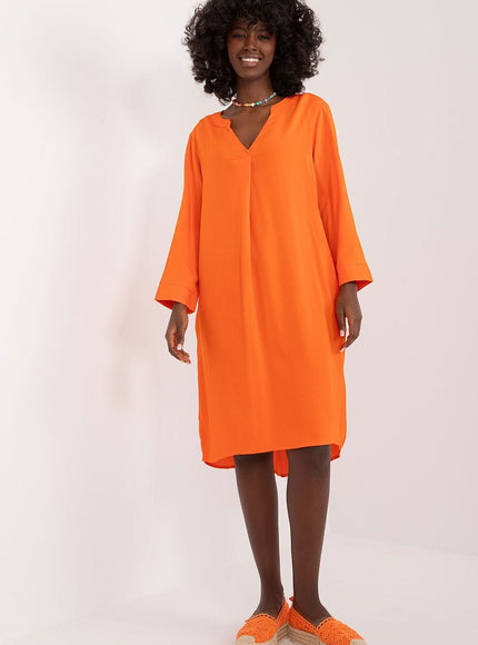 Robe orange fluide avec manches longues, coupe midi, idéale pour soirée simple ou événement décontracté.