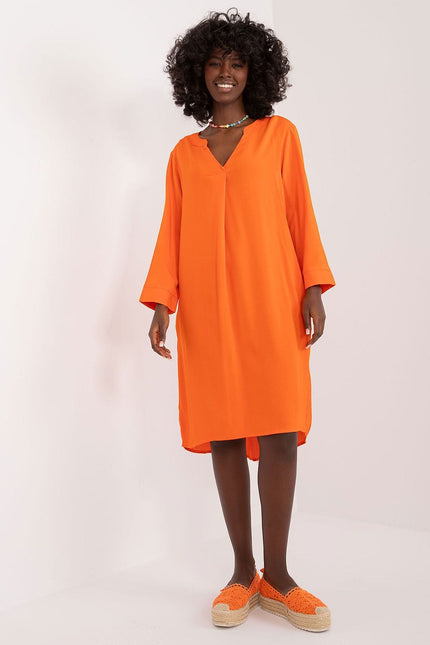 Robe orange fluide avec manches longues, coupe midi, idéale pour soirée simple ou événement décontracté.