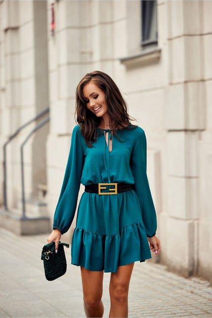 Robe verte chic courte à manches longues idéale pour cocktail ou soirée, avec ceinture noire pour une silhouette élégante.