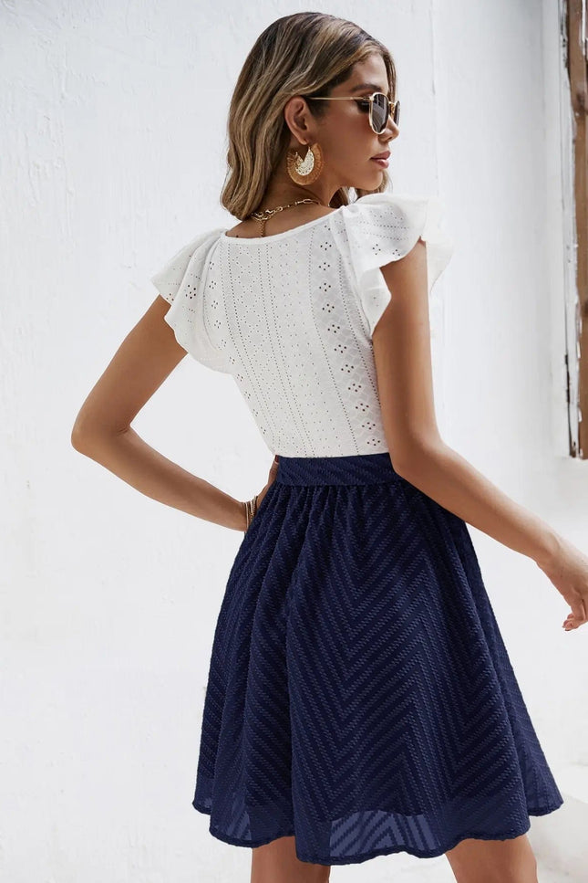 Robe chic blanche et bleue avec jupe à nouer et top en dentelle, manches courtes, idéale pour cocktail ou soirée.