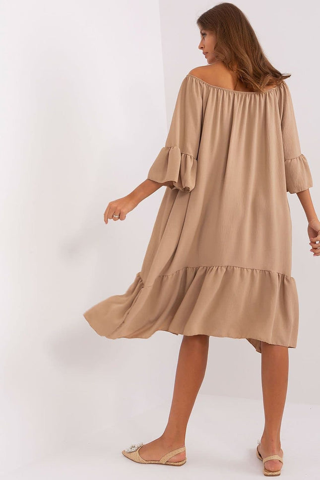 Robe champêtre invitée mariage beige midi à manches courtes et col élastique, silhouette trapèze avec ourlet à volant.