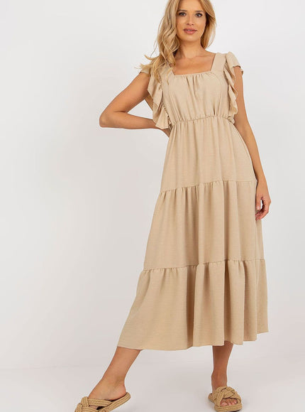 Robe beige midi évasée sans manches pour plage, style décontracté et fluide, idéale pour une sortie estivale ou une journée ensoleillée.