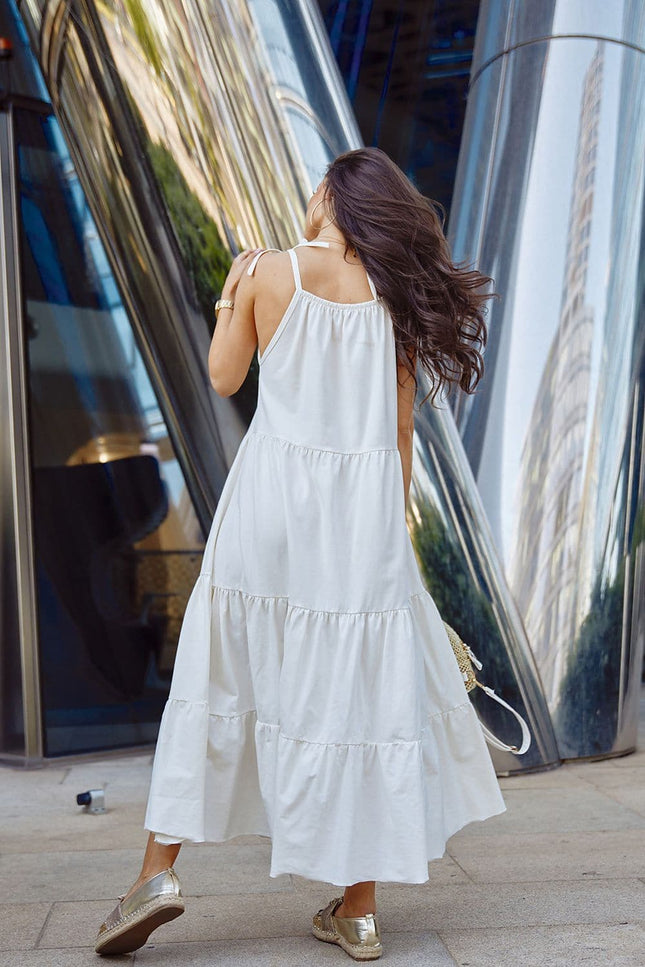 Robe d'été blanche longue fluide sans manches, idéale pour une soirée décontractée ou une promenade à la plage.