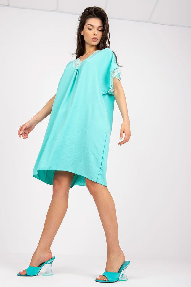 Robe d'été verte courte avec détails en dentelle, manches courtes et silhouette trapèze, idéale pour une soirée simple ou une balade à la plage.