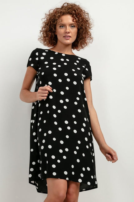 Robe noire à pois blancs, style casual chic, manches courtes, longueur midi pour soirée simple ou cocktail.