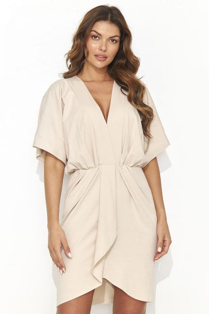 Robe de cocktail beige drapée midi avec manches courtes pour un événement chic et élégant.