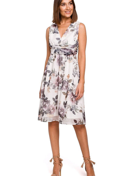 Robe midi fleurie blanche style soirée chic, idéale pour cocktail ou mariage, sans manches, décolleté en V, taille marquée.