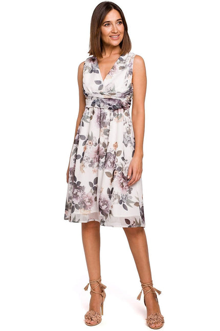 Robe midi fleurie blanche style soirée chic, idéale pour cocktail ou mariage, sans manches, décolleté en V, taille marquée.