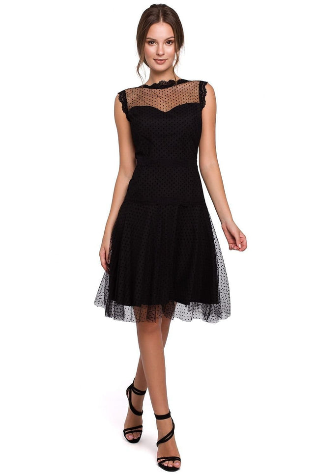 Robe de soirée chic noire en dentelle, style midi avec manches courtes et silhouette trapèze, idéale pour cocktail ou événement élégant.