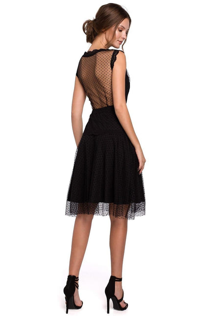 Robe soirée chic en dentelle noire, mi-longue avec manches courtes et silhouette trapèze, idéale pour cocktail ou événement.