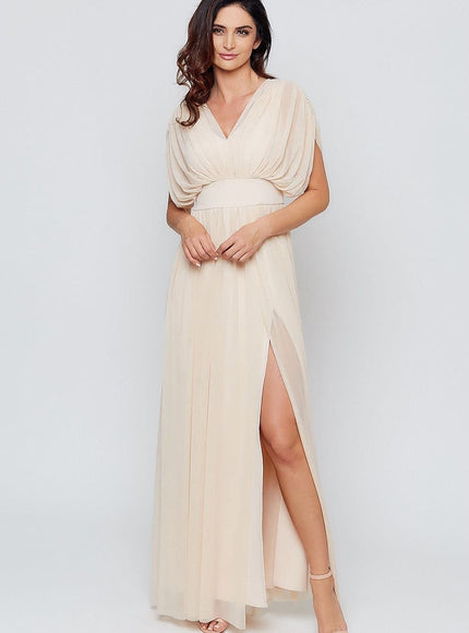 Robe empire beige fluide longue avec fente pour soirée et gala, manches courtes et silhouette élégante.