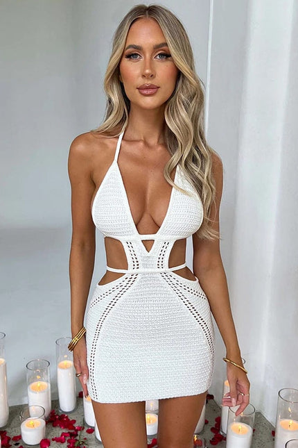 Robe blanche dos nu en maille courte sexy pour soirée, silhouette moulante avec sans manches et détails ajourés.