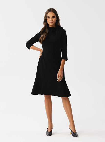 Robe noire chic midi à manches longues pour soirée, cocktail ou événement formel, coupe évasée élégante.