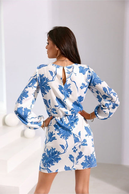 Robe florale blanche et bleue, style casual chic, courte avec manches longues, idéale pour une soirée ou un événement décontracté.