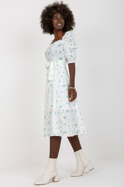 Robe fleurie blanche midi avec épaules dénudées et manches courtes pour cocktail ou mariage invité chic.