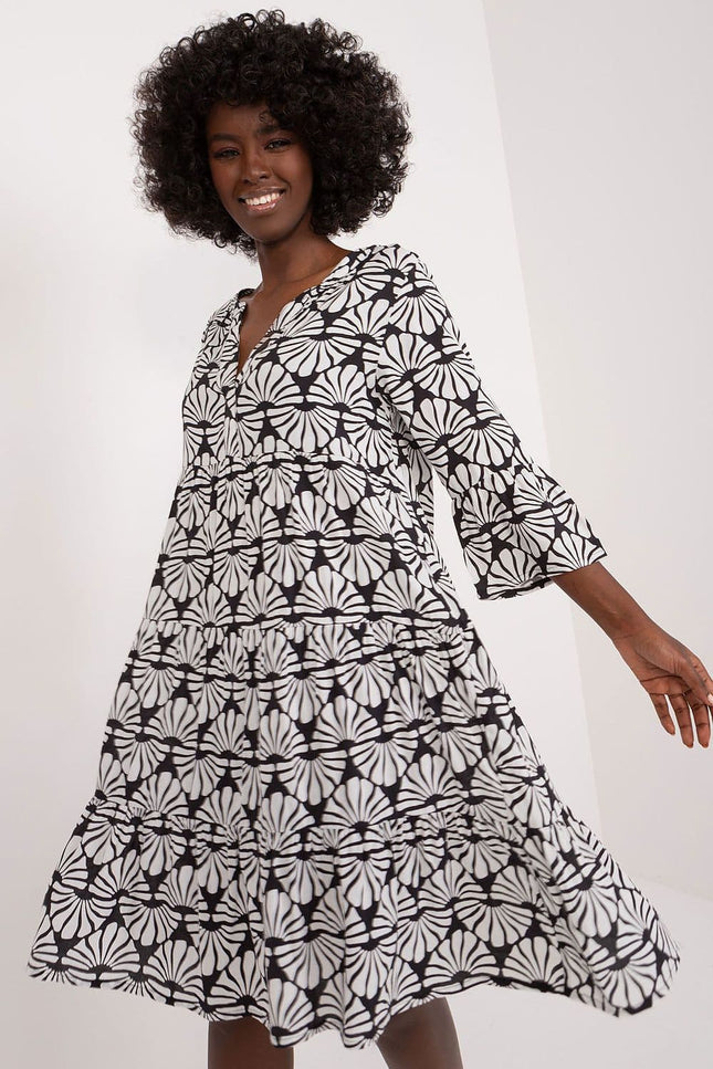 Robe fluide femme fleurie noir et blanc mi-longue avec manches trois-quarts, idéale pour une soirée casual ou un évènement de jour.