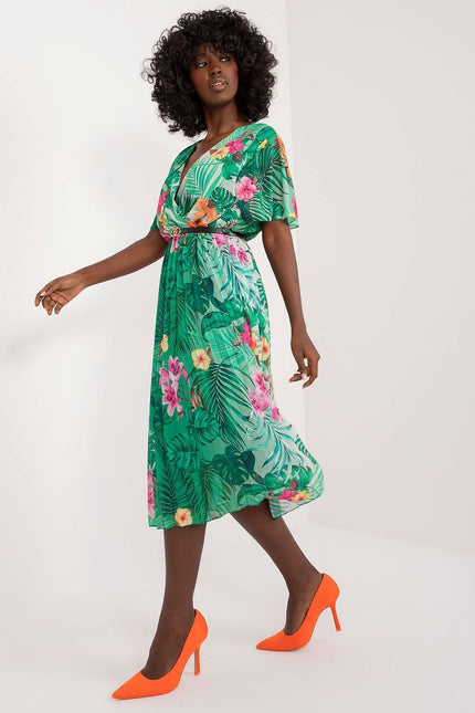 Robe d'été verte à motif floral, style bohème et décontracté, longueur midi avec manches courtes pour un look frais et élégant.