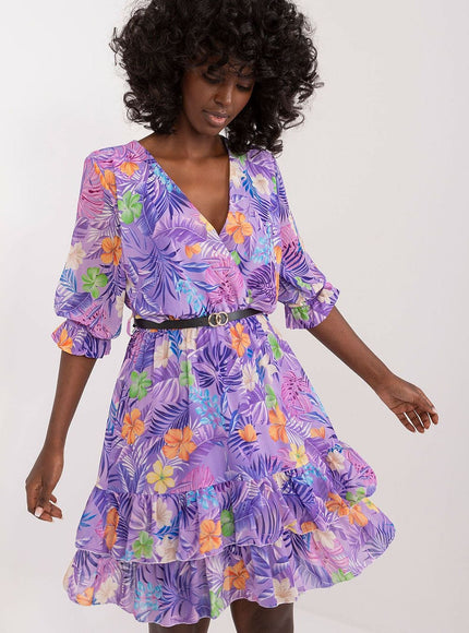 Robe d'été fleurie violette courte avec manches courtes et decolleté, idéale pour une soirée plage ou une sortie casual.