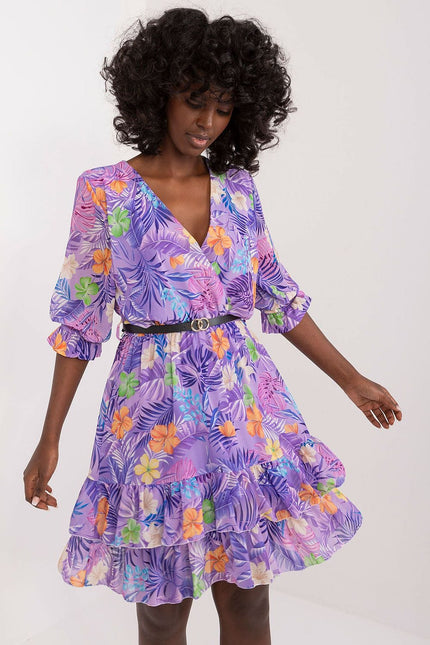 Robe d'été fleurie violette courte avec manches courtes et decolleté, idéale pour une soirée plage ou une sortie casual.