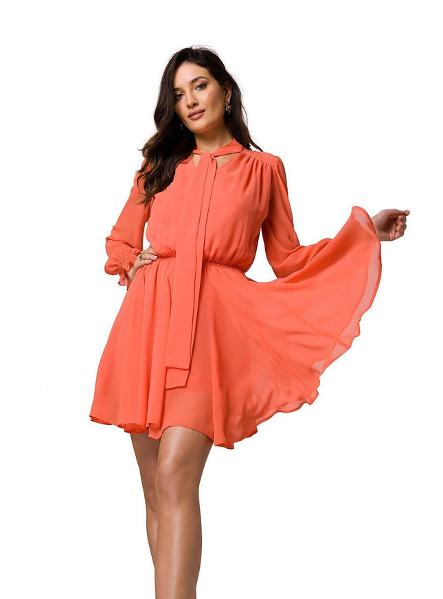 Robe de soirée courte orange avec manches longues et ceinture, idéale pour cocktail ou événement élégant.