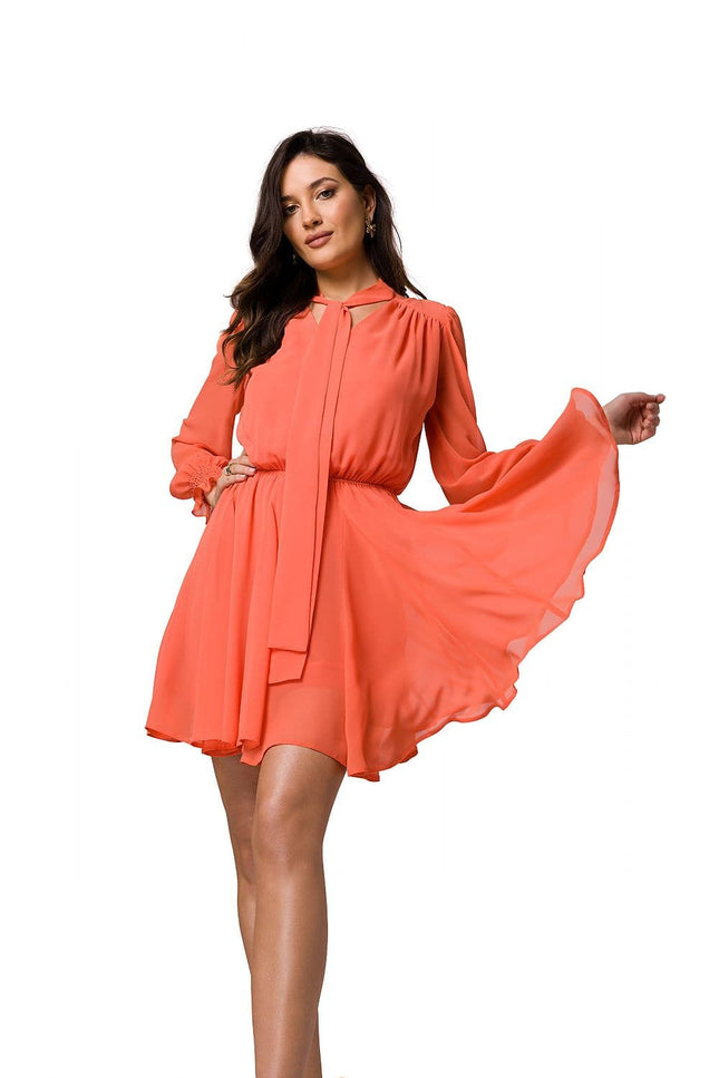 Robe de soirée courte orange avec manches longues et ceinture, idéale pour cocktail ou événement élégant.