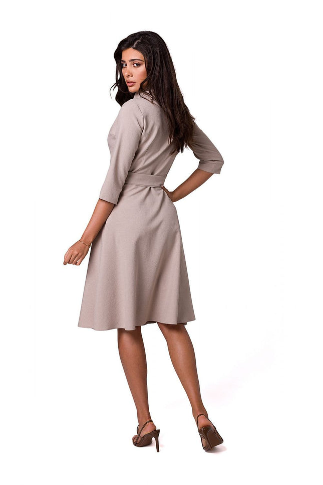 Robe habillée beige à manches longues et midi, idéale pour un cocktail ou une soirée élégante.