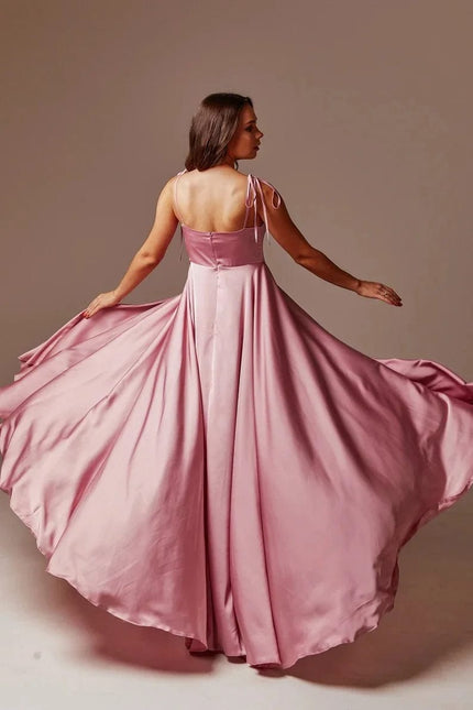 Robe rose longue élégante pour mariage invité chic avec dos nu et jupe ample en tissu fluide, parfaite pour une soirée ou un gala.