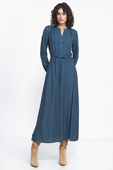 Robe longue bleue à pois blancs avec manches longues et boutons pour un style casual ou pour travail, silhouette droite et ceinturée.