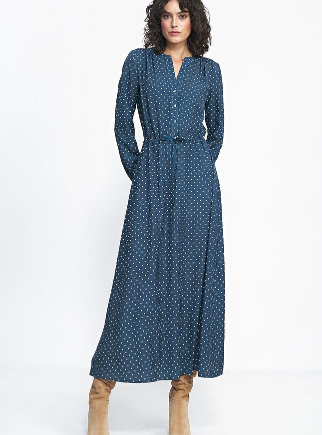 Robe longue bleue à pois blancs avec manches longues et boutons pour un style casual ou pour travail, silhouette droite et ceinturée.