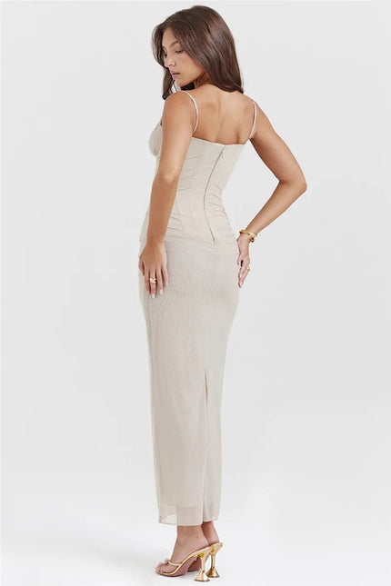 Robe longue beige à bretelles spaghetti pour soirée chic, silhouette moulante et élégante, parfaite pour un gala ou un mariage.