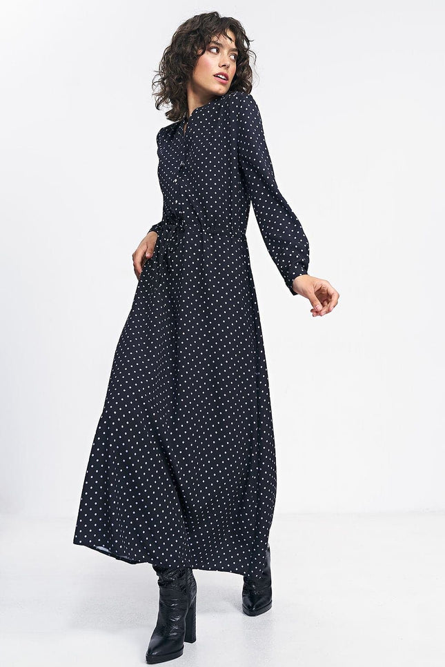 Robe noire à pois longue avec manches longues pour soirée chic ou cocktail, silhouette trapèze et élégante.