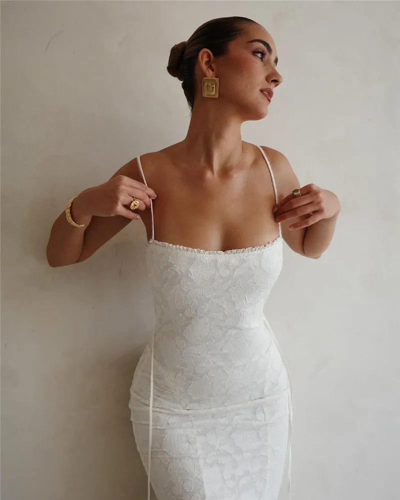 Robe longue en dentelle blanche pour mariage, silhouette moulante, chic avec bretelles fines et décolleté discret.