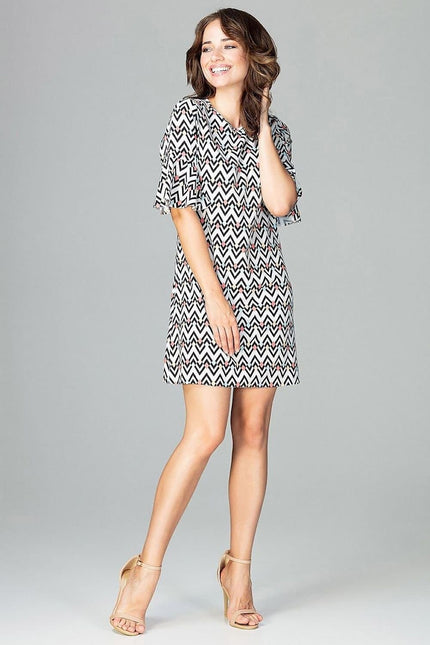 Robe courte à motif zigzag noir et blanc, manches courtes et silhouette droite, idéale pour cocktail ou soirée simple.