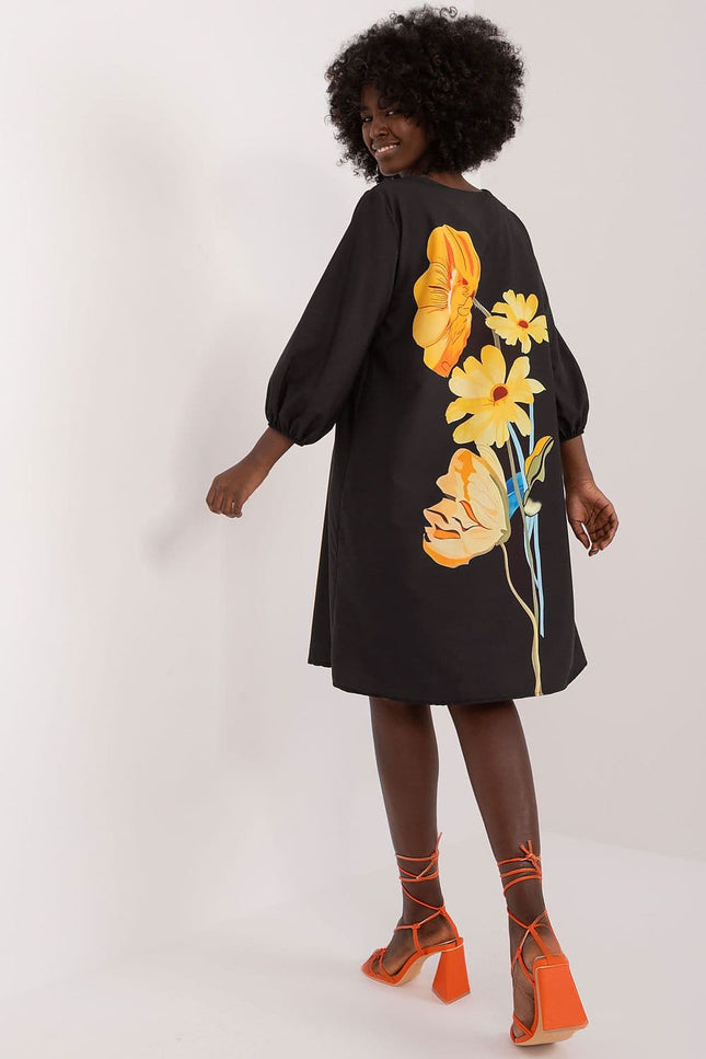 Robe noire florale style casual avec manches longues et longueur midi, idéale pour une soirée simple ou un événement casual chic.