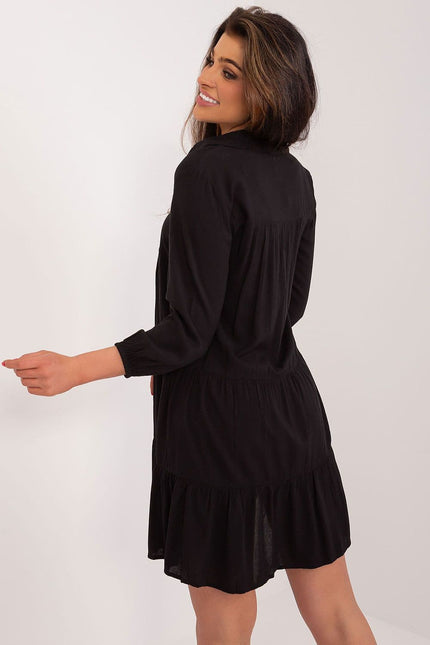 Robe fluide noire pour soirée chic avec manches longues et coupe courte, idéale pour une allure élégante.