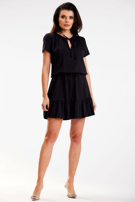 Robe noire courte fluide pour femme avec manches courtes et détail nœud, idéale pour une soirée simple ou un cocktail.