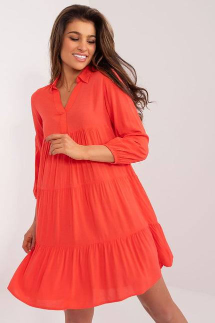 Robe d'été fluide orange avec manches longues, idéale pour une tenue décontractée ou une sortie plage.