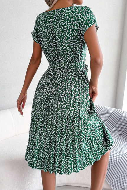 Robe midi fleurie verte à ceinture à nouer pour cocktail ou événement estival, adaptée pour une silhouette trapèze avec manches courtes.