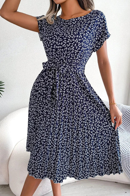 Robe midi florale bleue et blanche avec ceinture à nouer pour cocktail ou soirée d'été, style chic et féminin.