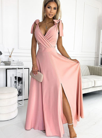 Robe soirée rose longue fendue avec manches courtes et détails noeuds pour événement chic et élégant.