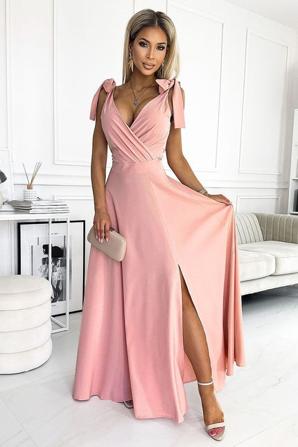 Robe soirée rose longue fendue avec manches courtes et détails noeuds pour événement chic et élégant.