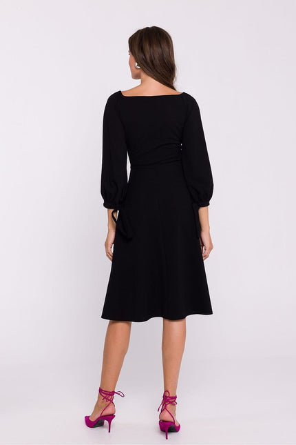 Robe noire midi chic avec manches longues pour soirée cocktail ou événement gala, silhouette trapèze.