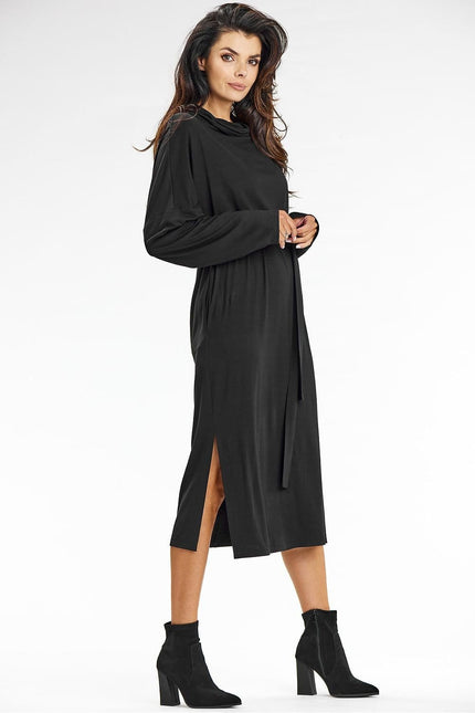 Robe noire midi élégante pour cocktail, manches longues, silhouette droite et fendue.